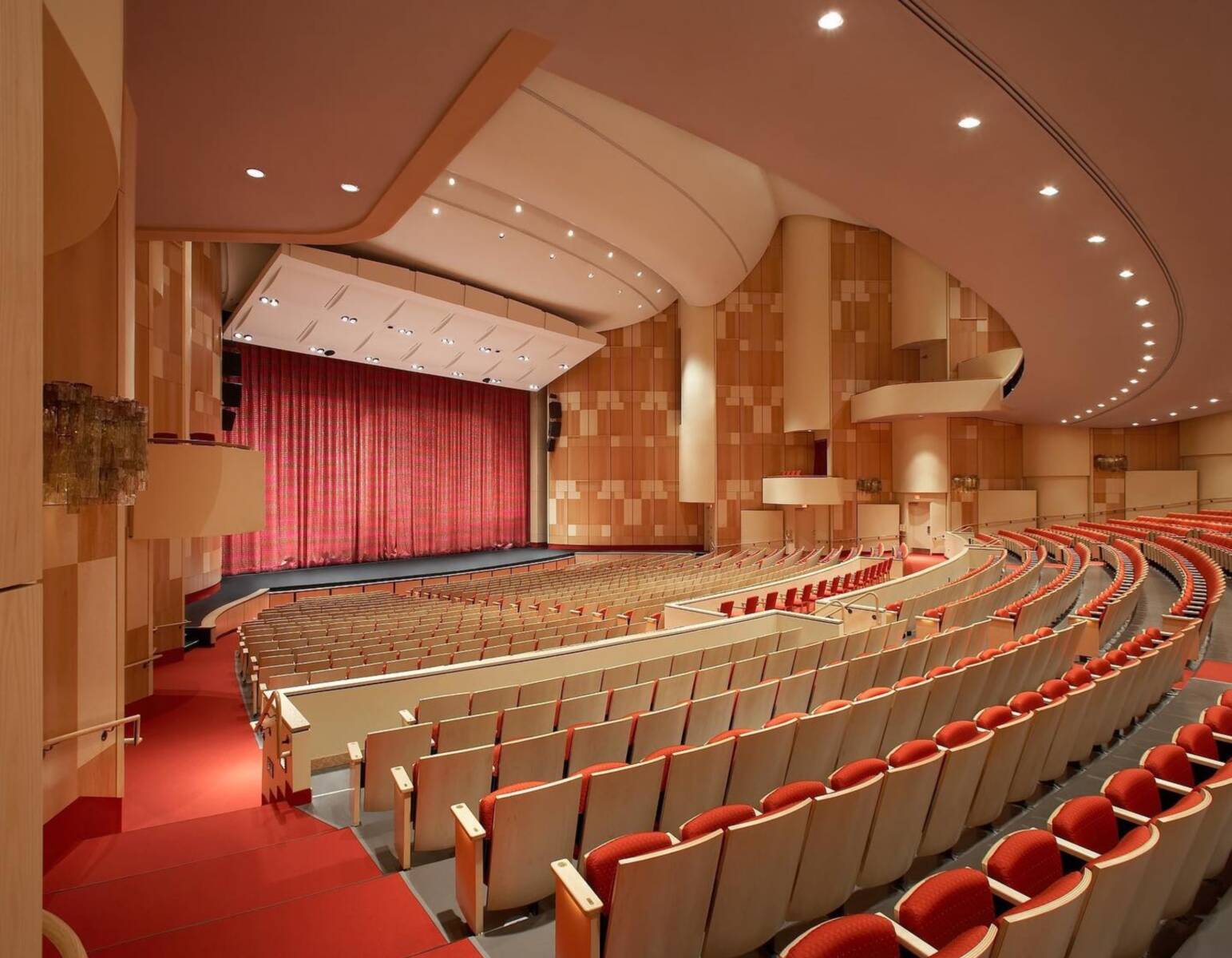 An auditorium comprising hundreds of seats over a nicely themed, red and gray flooring contrast