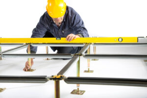 Access flooring, man installing a raised access flooring system
