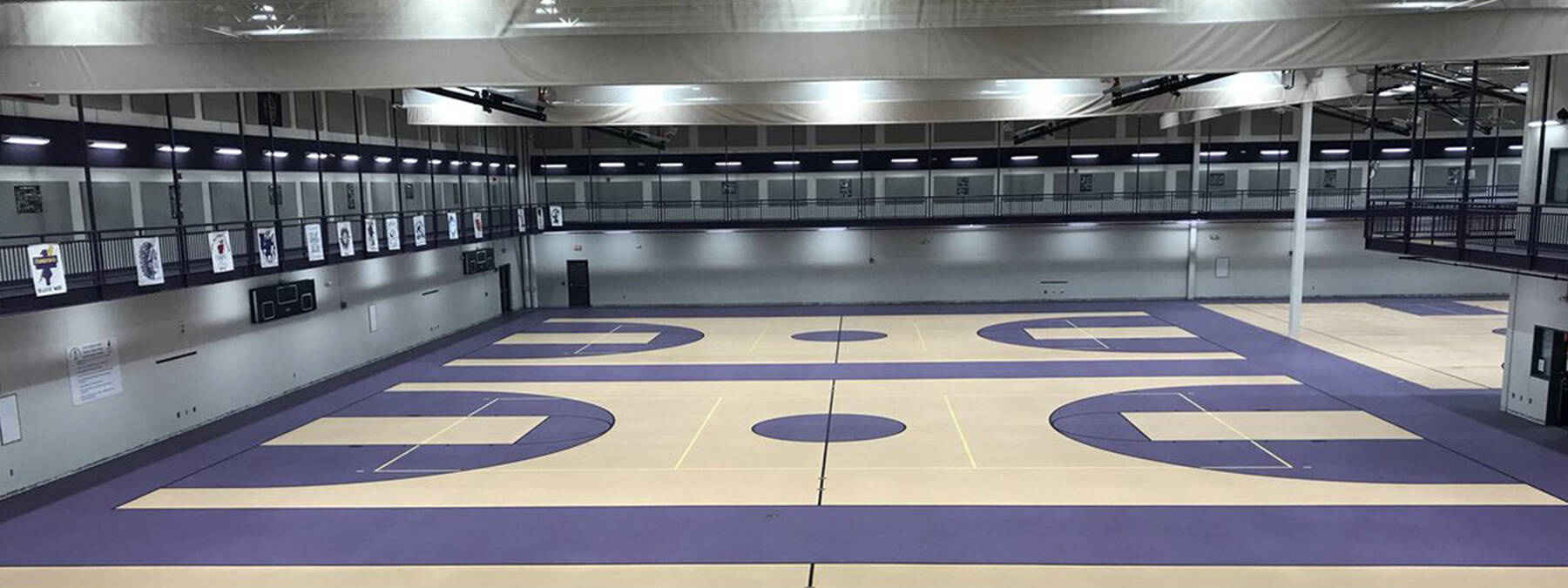 Wide angle of Bellevue High School basketball courts executed through a commercial flooring, purple theme