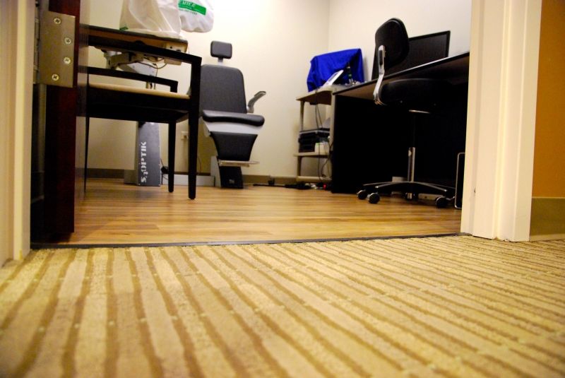 Dr. Rosanova’s Office filled with warm neutral flooring combination of vinyl plank, ceramic tile, and Bentley broadloom