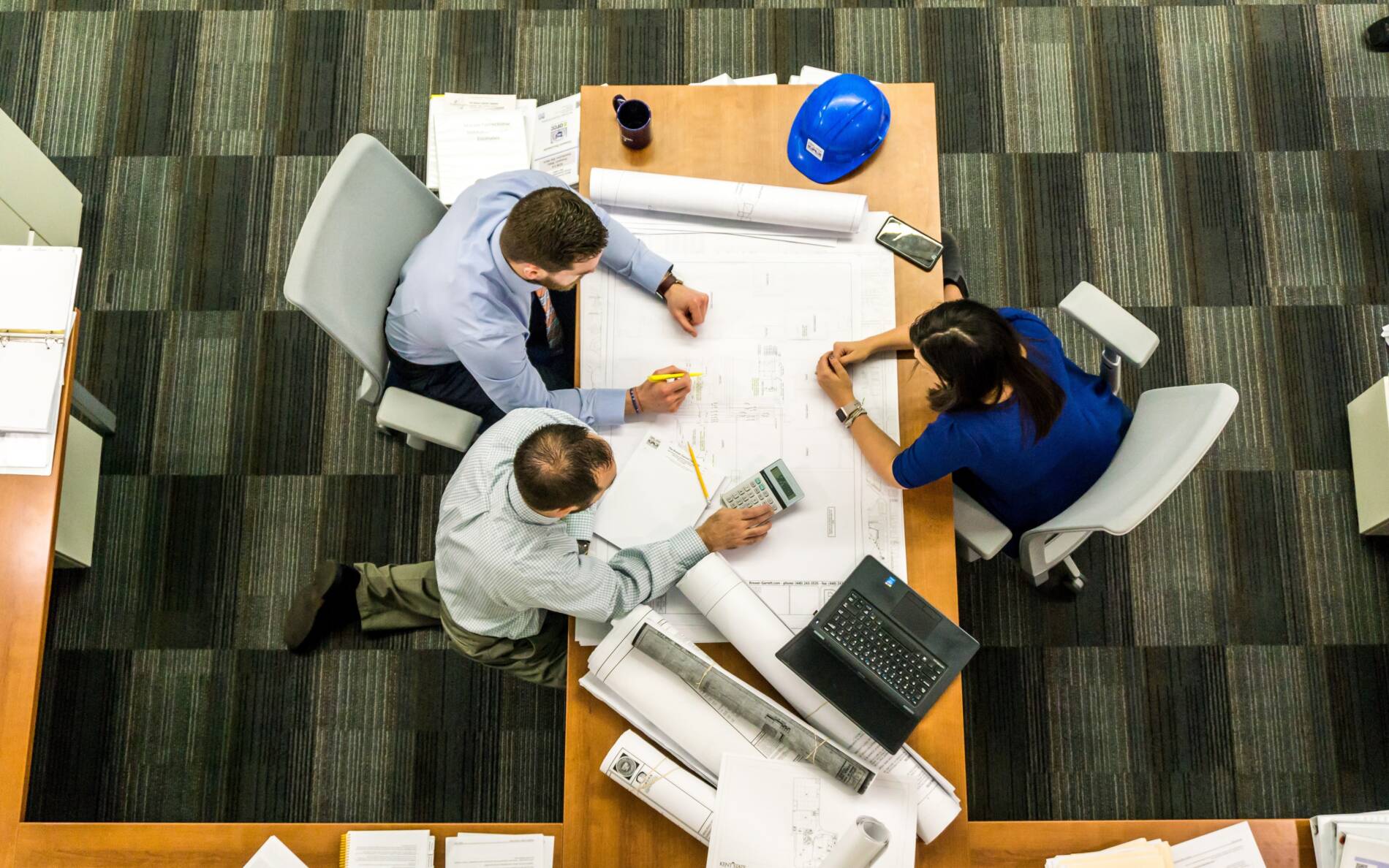 Stock, overhead photo of multiple workers designing a plan for interior design